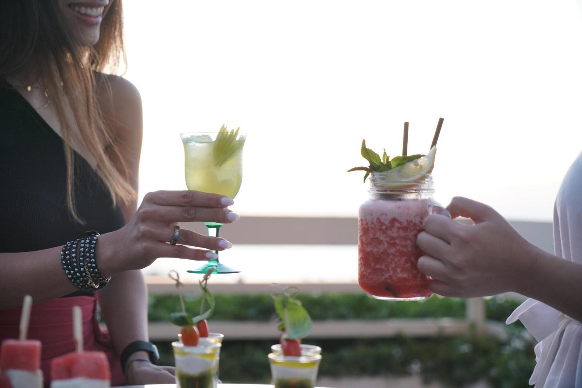 Готель Gefinor Rotana - Бейрут Екстер'єр фото Two people holding cocktails